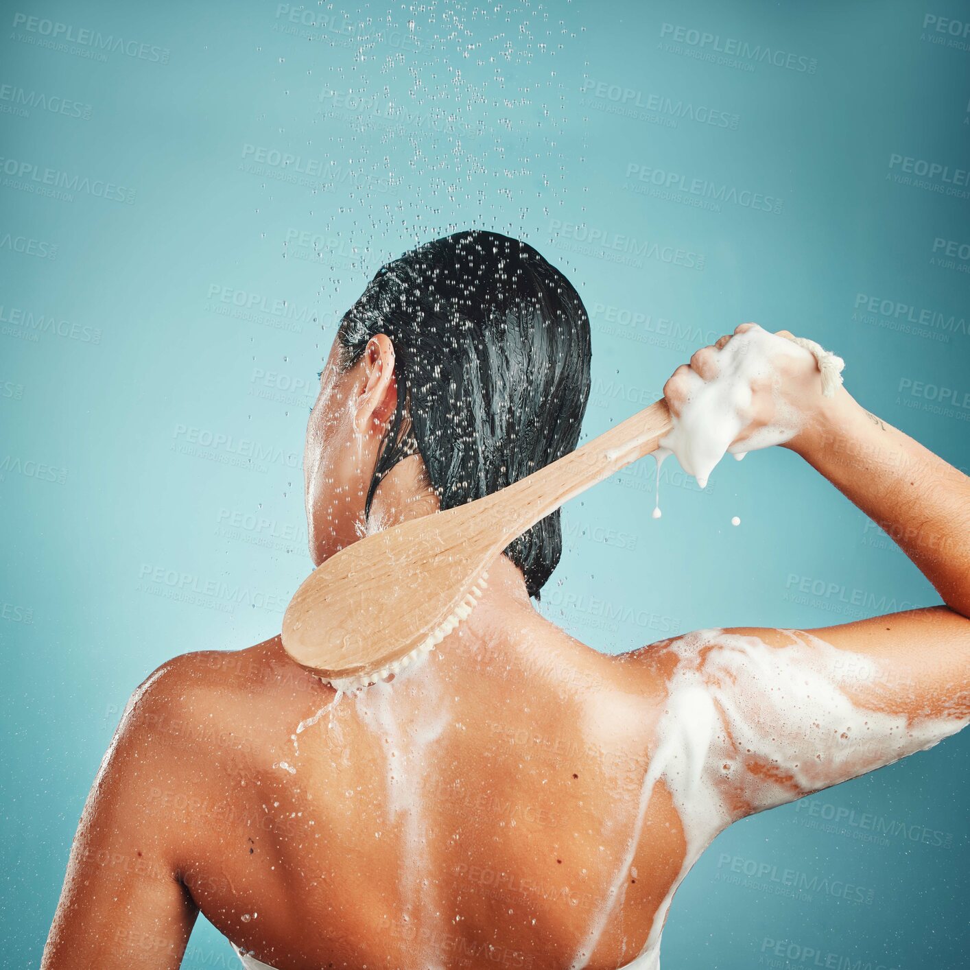 Buy stock photo Skincare, brush and shower by woman in studio for wellness, cleaning and hygiene on blue background mockup.  Water splash, hair and back of girl model in beauty splash, water and cleaning in bathroom