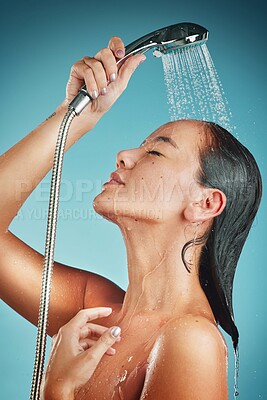 Buy stock photo Cleaning, water and shower, woman with hygiene and body care, washing and beauty against blue studio background. Skin hydration, skincare and wellness with Asian model for grooming and clean.