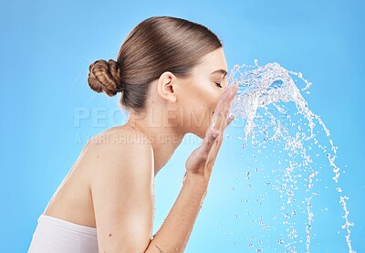 Buy stock photo Skincare, water and woman cleaning face in studio on blue background for wellness, hygiene and facial cleanse. Beauty, hydration and girl washing skincare products, cosmetics and makeup with splash