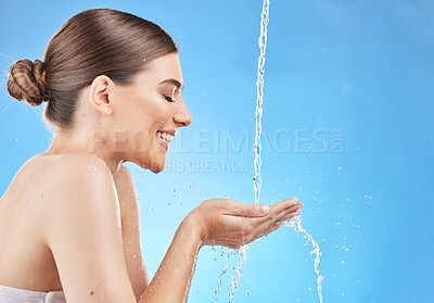 Buy stock photo Water, splash and woman in a studio for skincare, beauty and natural organic face routine in a studio. Wellness, health and happy girl model doing a clean and healthy treatment by a blue background.