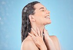 Woman shower, smile and studio with water, washing and cleaning for skincare, cosmetic health or wellness. Happy model, water drops or cosmetics for self care, skin or healthy body by blue background