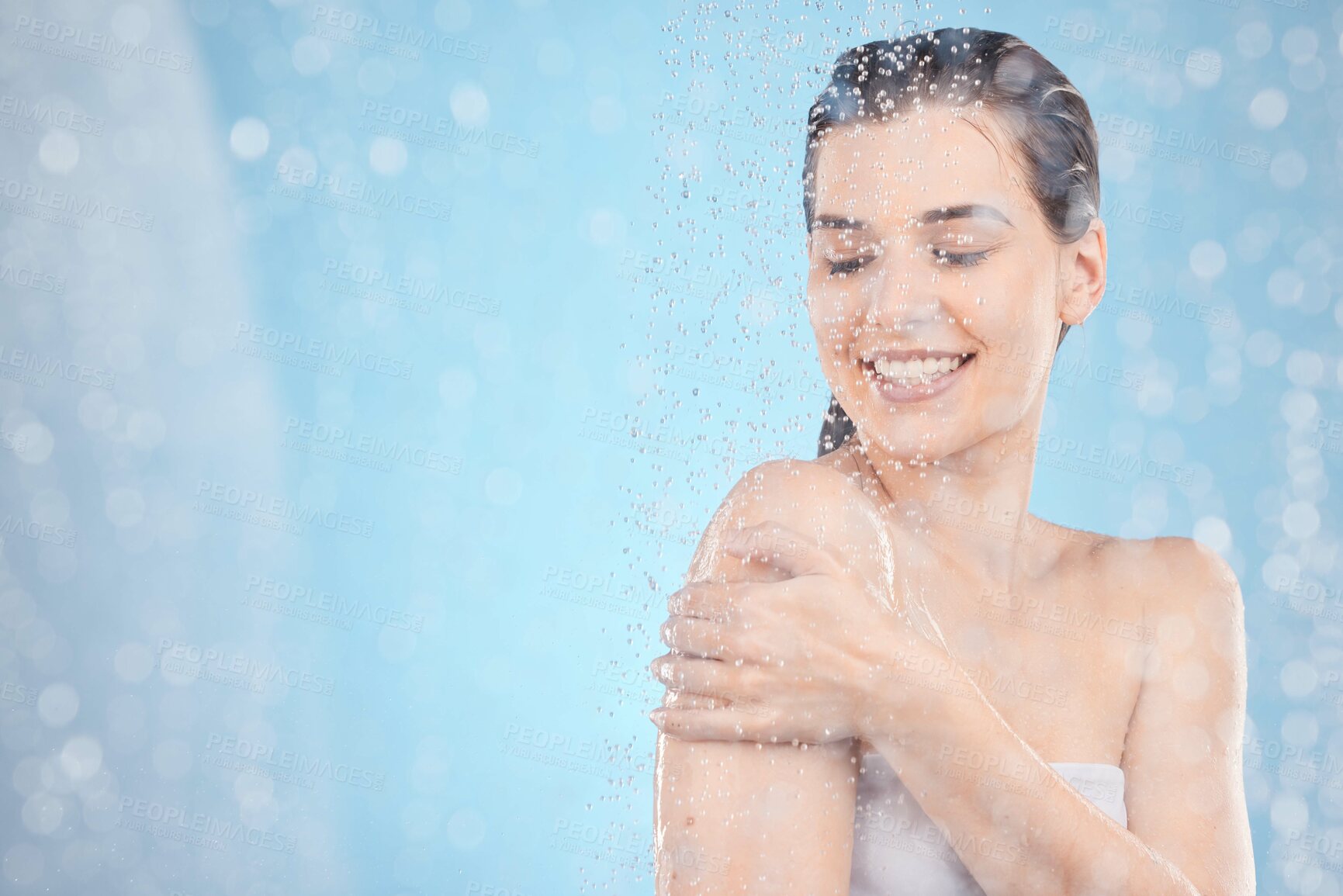 Buy stock photo Cleaning, shower and woman with water in studio on blue background for beauty, wellness and body care. Spa hydration, skincare and happy girl washing for self care, health and hygiene in water drops