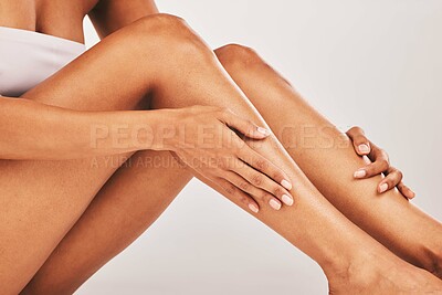 Buy stock photo Woman, hands and legs in skincare beauty, cosmetics or moisturizer against gray studio background. Hand of female touching soft, smooth or gentle leg for healthy skin, wellness or self love and care