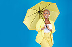 Black woman, umbrella and face with smile in studio for life insurance and security isolated on blue background. Shield, happiness and person for fashion, style and confidence with mockup space