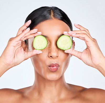 Buy stock photo Cucumber, eyes and woman with natural beauty, skincare and wellness isolated in studio white background with kiss. Aesthetic, detox and young person relax with facial or face treatment as dermatology