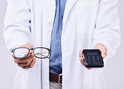 Buy stock photo Hands, glasses and machine for pos payment, healthcare and sales for optometrist by white background. Doctor, fintech and vision expert with frame, lens and helping for wellness, health or eye care