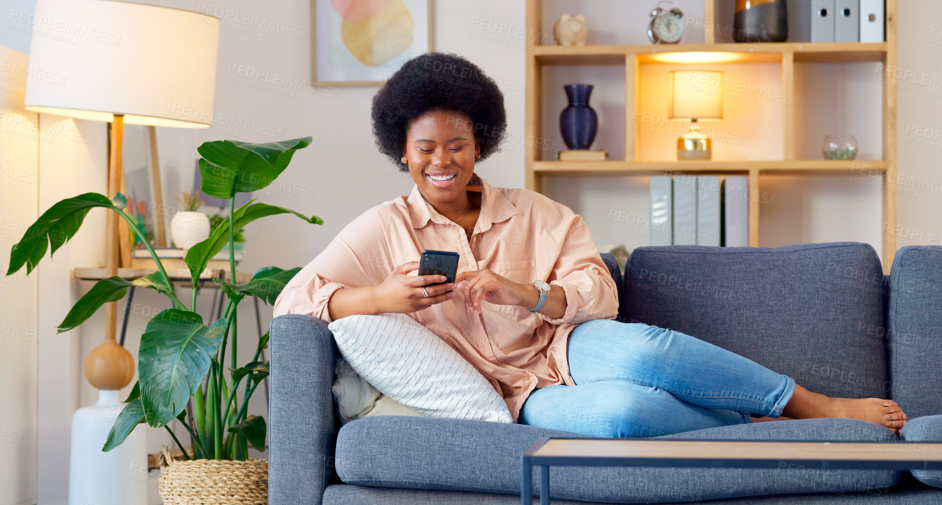 Buy stock photo Black woman, smile and living room sofa with phone text and funny web meme at home. Happy, African female person relax and browsing social media on mobile app on the couch with website scroll