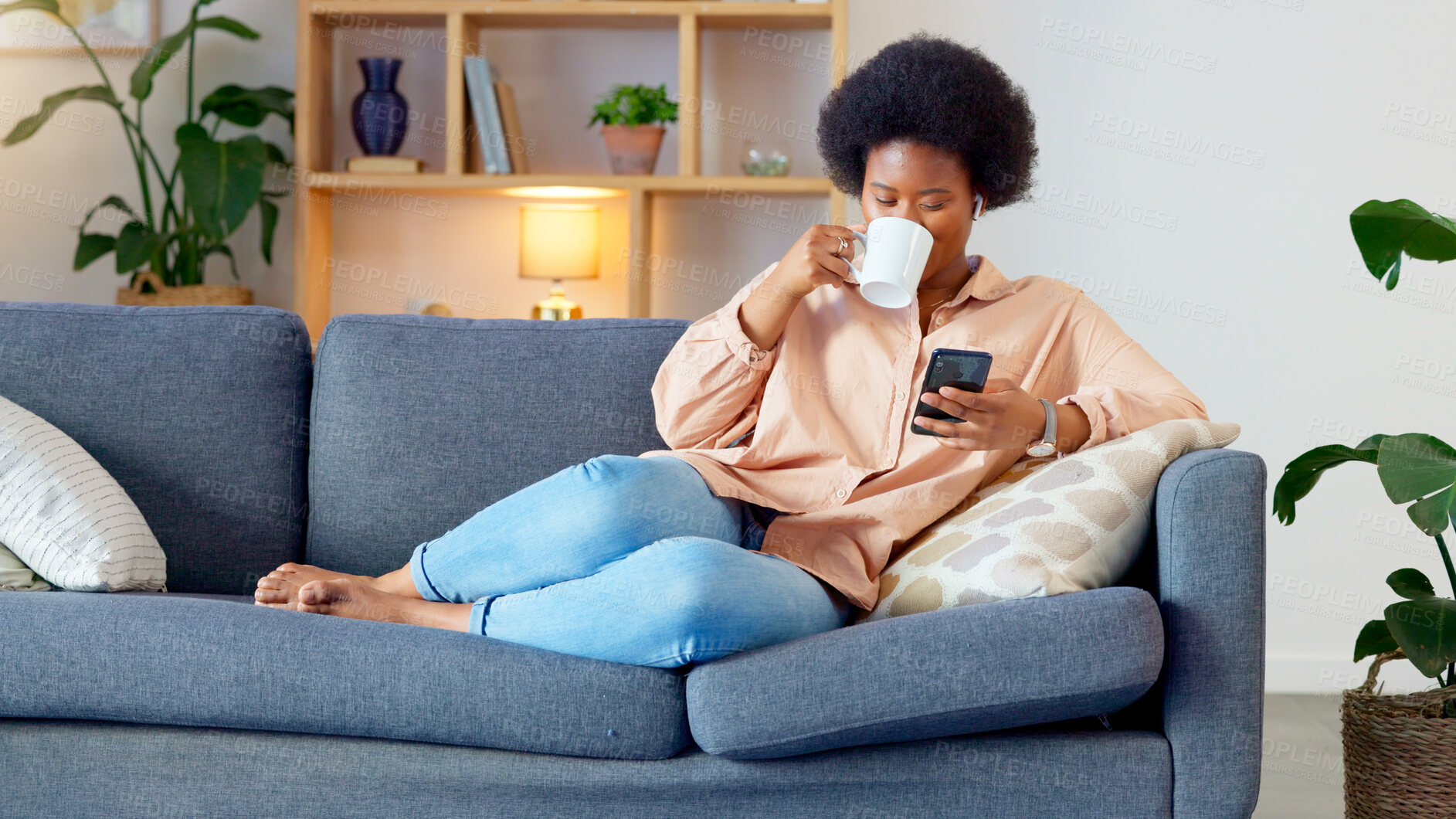 Buy stock photo Coffee, phone and relax with black woman on sofa for search, streaming and social media. Website, internet and communication with person in living room at home for contact, network and mobile app