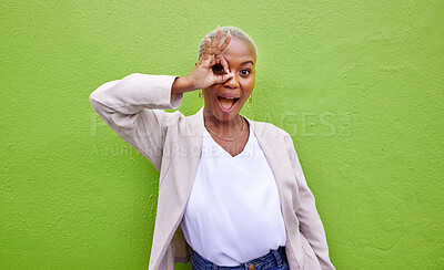 Buy stock photo Perfect, surprise and portrait of black woman on a green wall for fashion, review or looking. Happy, ok and an African girl or person with a gesture on an eye for wow, circle or trendy on a backdrop