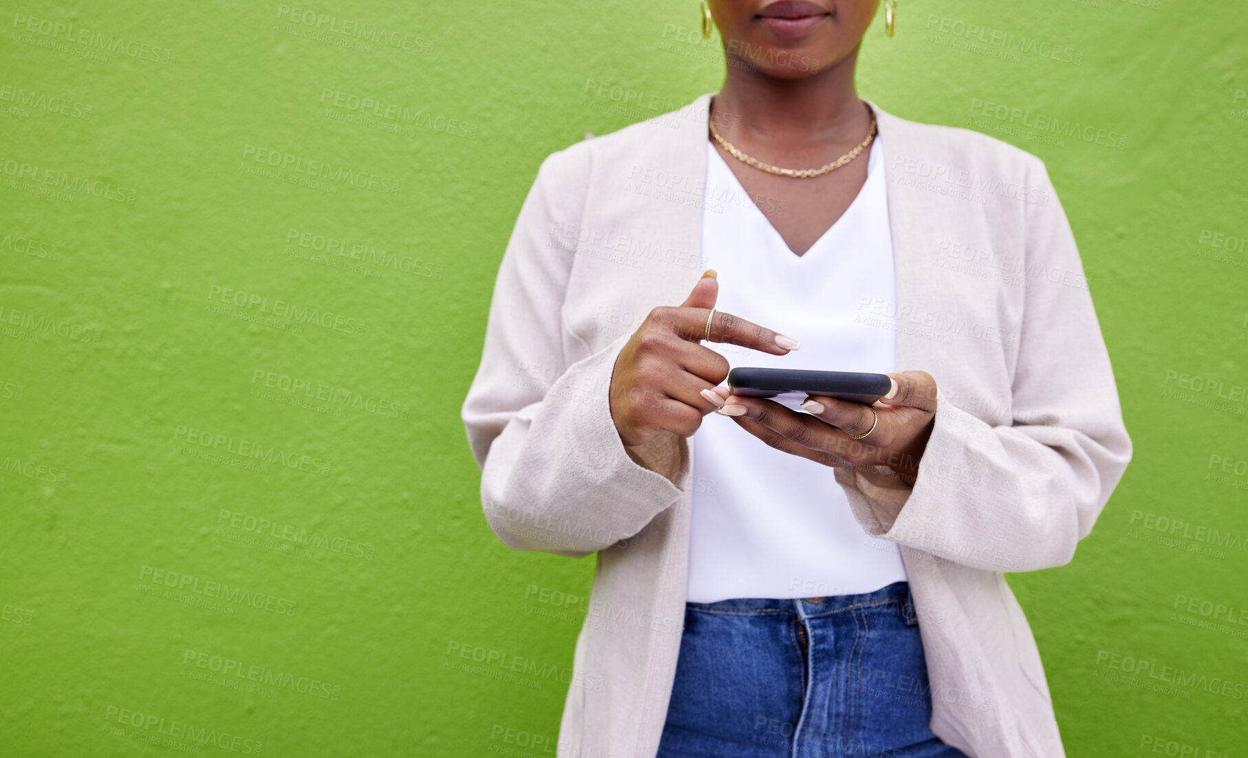 Buy stock photo Hands, internet and phone for communication by a wall or green background for connection. Closeup of a woman with a smartphone for social media search, networking and mobile app chat or mockup space