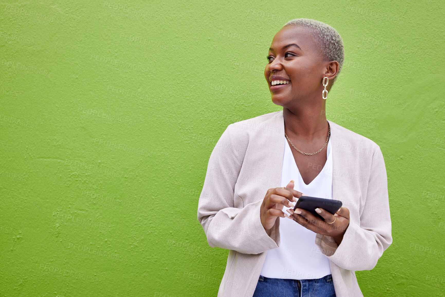 Buy stock photo Woman, thinking and phone for communication by a wall or green background with internet. Happy African female person outdoor with a smartphone for social media, networking app and chat mockup space