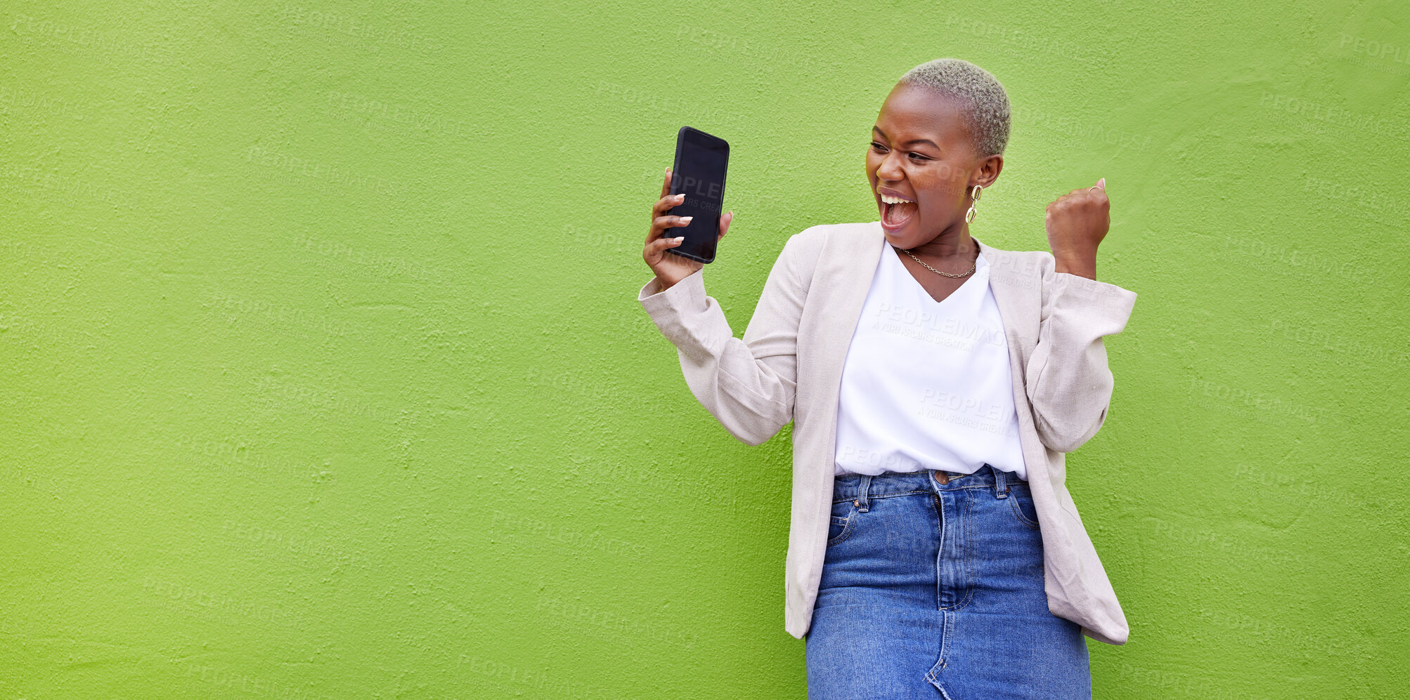 Buy stock photo Woman, celebrate and phone screen with mockup by a wall or green background with wow advertising. Excited African person or winner with a smartphone for competition, promotion or website banner space