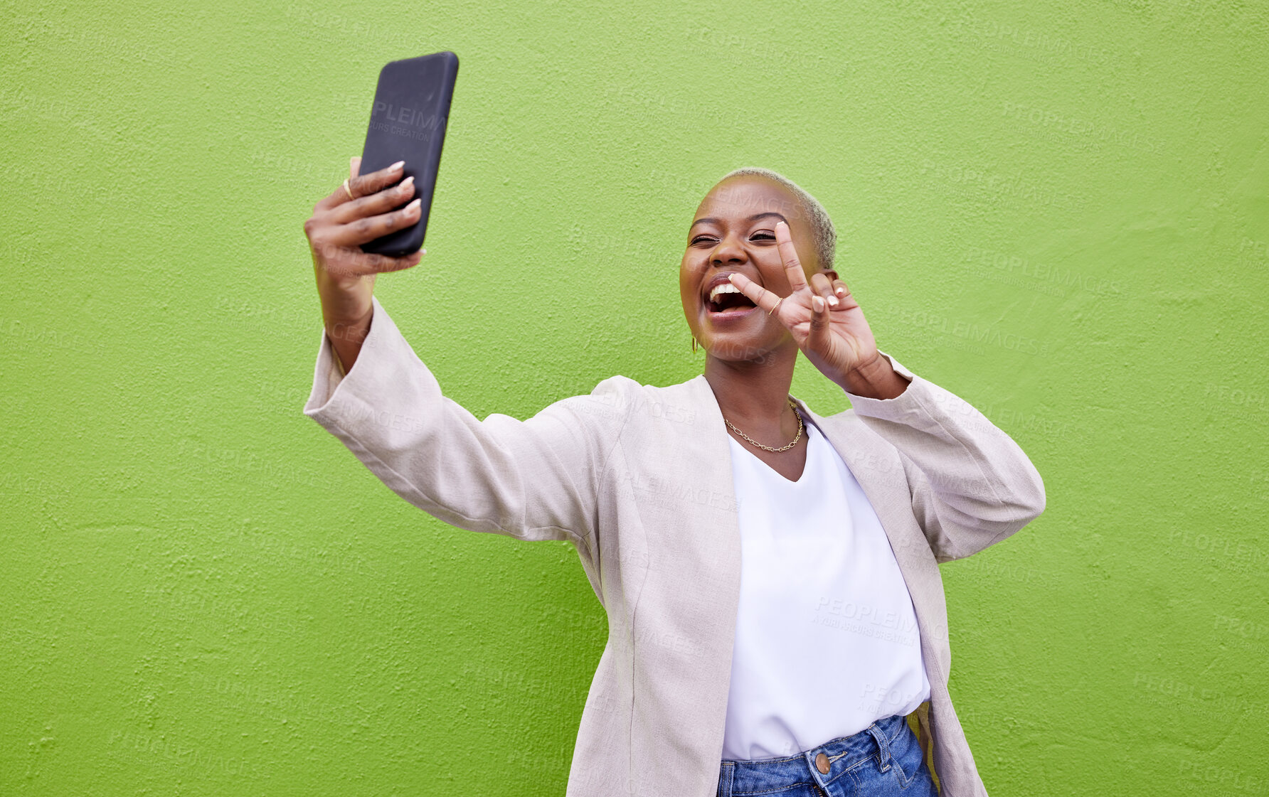 Buy stock photo Woman, selfie and peace or hand sign by a wall or green background with social media. Excited african person with a profile picture, memory and influencer post or vlog with happy emoji outdoor