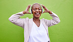 Music, headphones and happy black woman dance on green wall background mockup space. Radio, singing and African person streaming podcast, hearing audio or listening to sound of jazz media for freedom