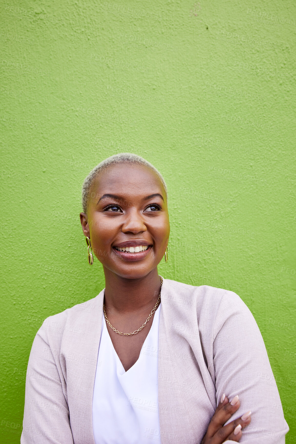 Buy stock photo Happy, crossed arms and young black woman by a green wall with classy and elegant jewelry and outfit. Happiness, smile and African female model with positive and confident attitude with mockup space.