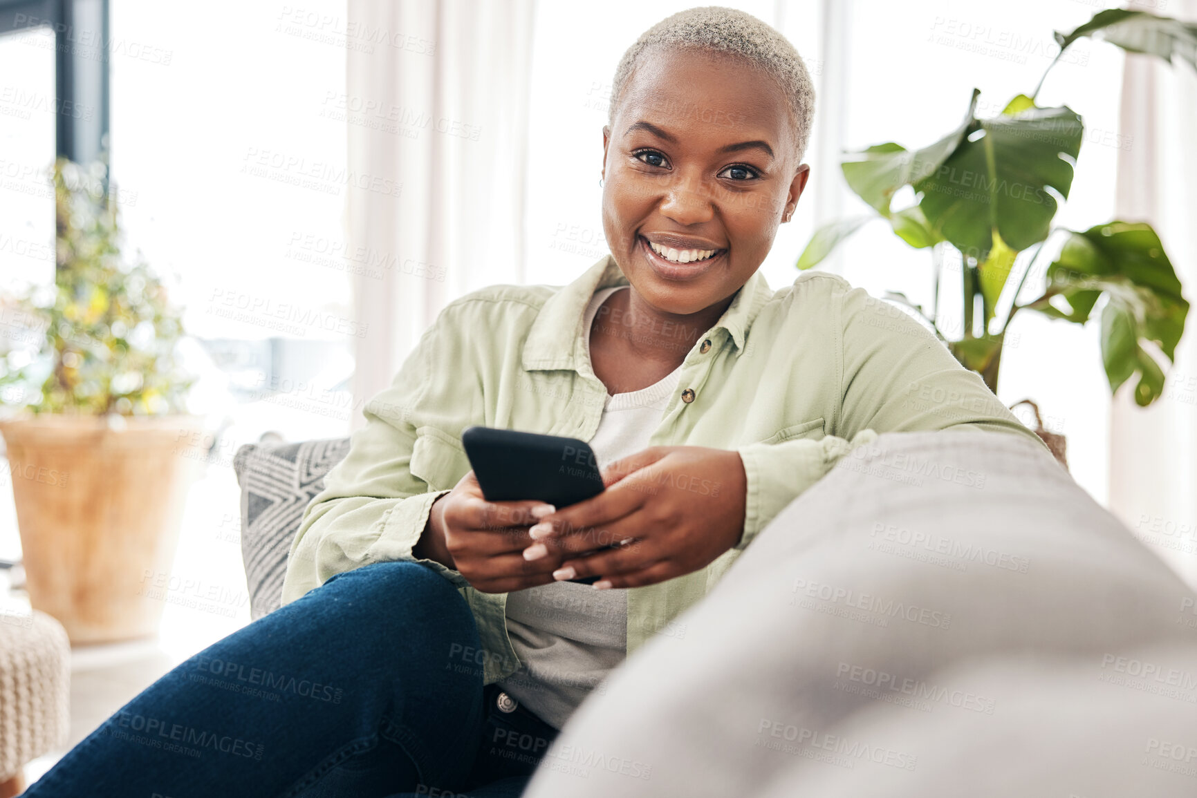 Buy stock photo Woman, portrait and smile with phone on couch for social media post, search tech contact or subscription to mobile games. Happy african person, smartphone user and download digital multimedia at home