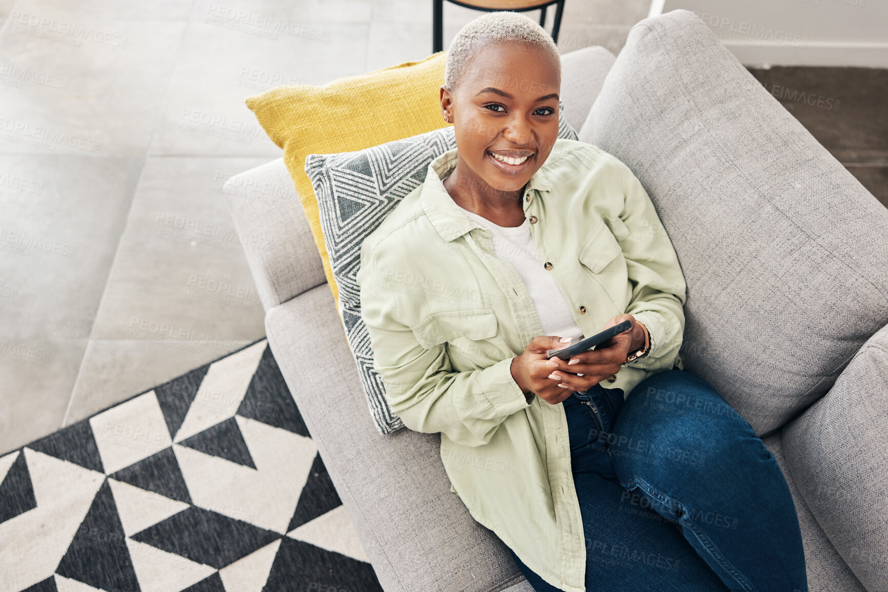 Buy stock photo Woman, portrait and relax with phone on couch for social media, text chat and contact at home from above. Happy african person, smartphone and download mobile games, digital multimedia and dating app