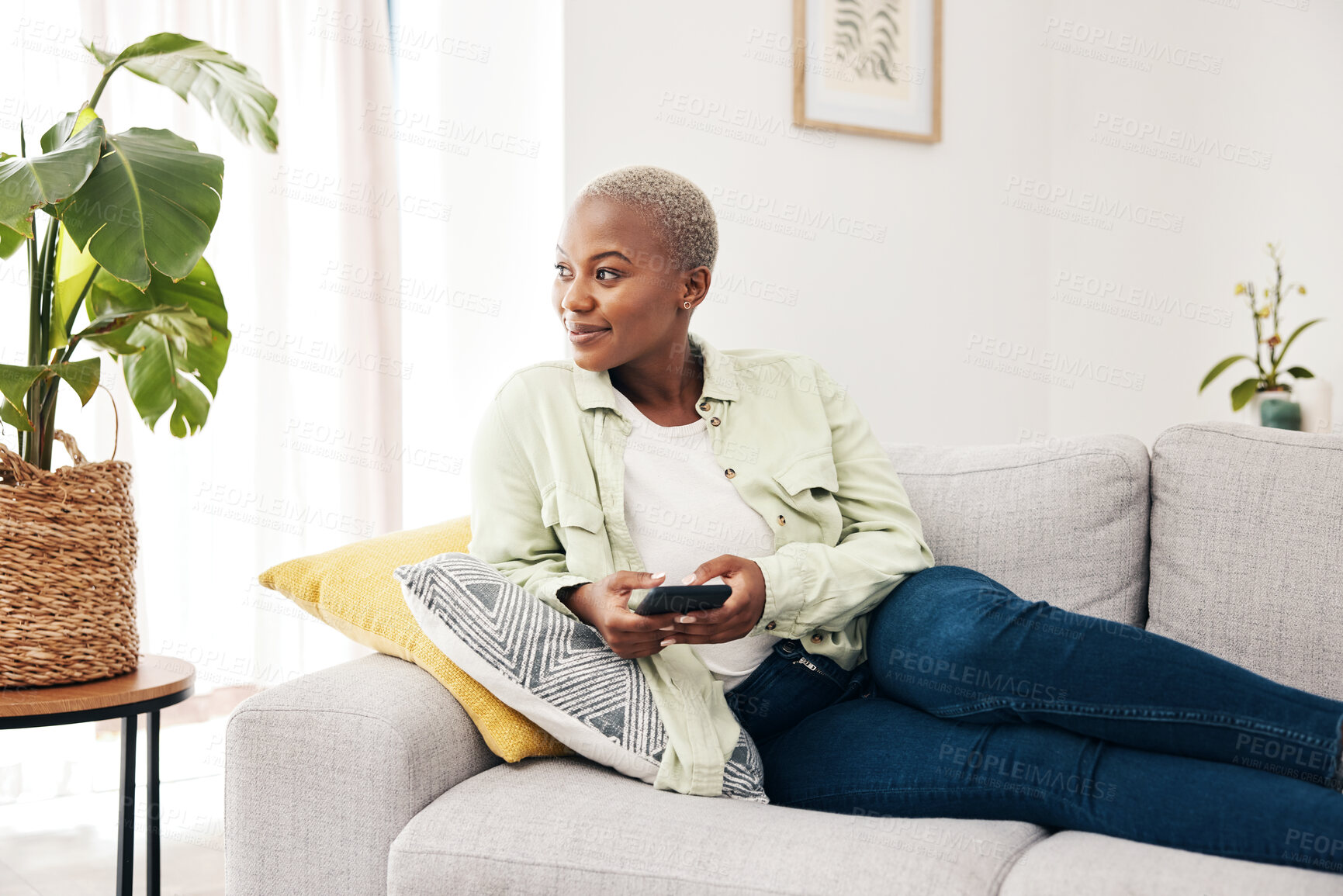 Buy stock photo Woman, smile and thinking with smartphone on sofa for social media post, digital contact and user connection. Happy african person, mobile and idea to download app, search subscription or web at home