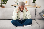 Stress, headache and pain with a black woman on a sofa in the living room of her home for mental health. Anxiety, burnout or vertigo and a young person in an apartment with depression or a migraine