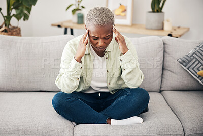 Buy stock photo Stress, headache and pain with a black woman on a sofa in the living room of her home for mental health. Anxiety, burnout or vertigo and a young person in an apartment with depression or a migraine