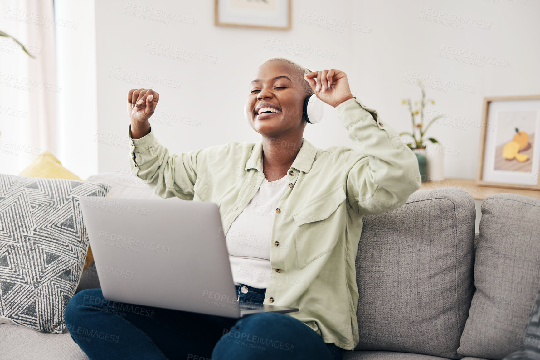 Buy stock photo Music, headphones and black woman with laptop on sofa dance, happy and free in her home. Radio, earphones and African female dancing to online feel good podcast in living room smile for subscription