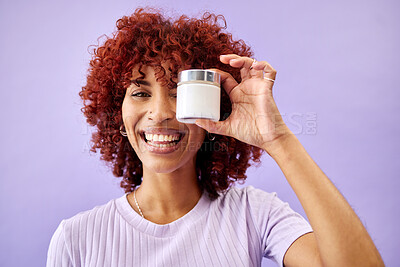 Buy stock photo Portrait, beauty and cream for skincare with a woman holding a container in studio on a purple background. Face, smile and promotion of a product or serum for antiaging with a happy young model