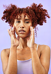 Woman, hair and beauty with hands on face in a studio, red curls and dermatology with makeup isolated on purple background.  Haircare, cosmetics and curly hairstyle with model from Brazil in portrait