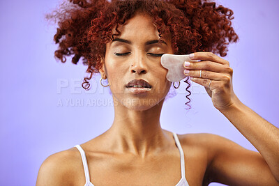 Buy stock photo Gua sha, skincare and face of woman in studio for facelift, wellness or anti aging on purple background. Stone, beauty and lady model with facial, massage or collagen, lymphatic drainage or cosmetic