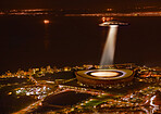 UFO, light and city in night, alien invasion and search with light on stadium in Cape Town. UAP ship, flying saucer and tractor beam in dark cityscape, metro or cbd for survey, inspection and flight