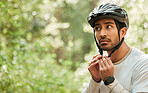 Cycling man, ready and helmet with thinking in forest, buckle and mockup space for training, adventure or transport. Guy, idea and safety with ppe, countryside or preparation in woods, park or nature