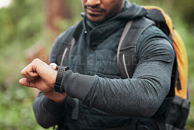 Hand, watch and a man hiking in the forest closeup for freedom, travel or adventure outdoor in nature. Time, fitness and recreation with a hiker in the woods to discover or explore the wilderness