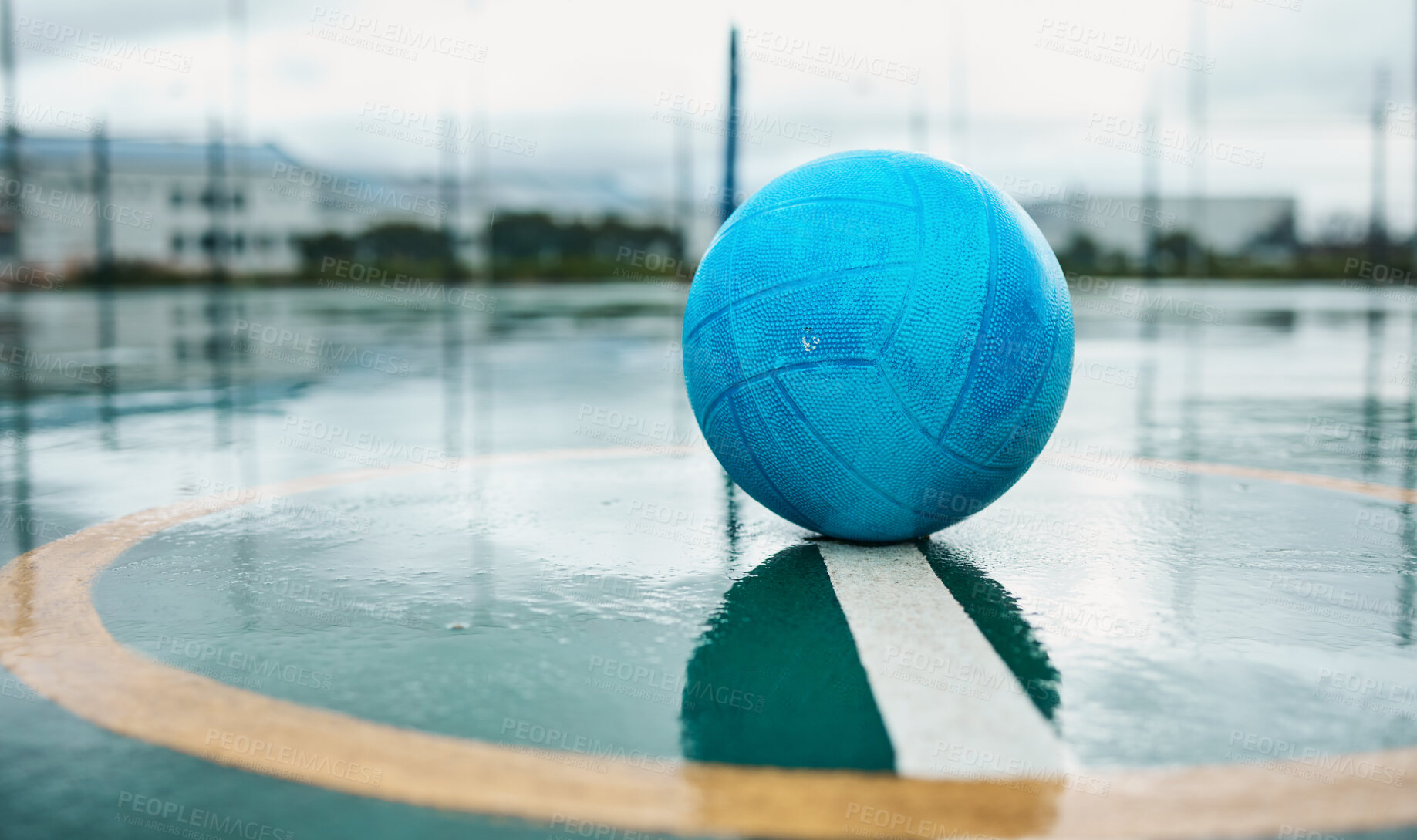 Buy stock photo Netball, wet ground and outdoor on sport, training and school court for game and competition. Isolated, raining and circle with blue ball on floor with exercise and fitness practice equipment