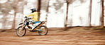 Motorcycle, fast and motion blur with a sports man on space in the forest for dirt biking. Bike, fitness and power with a person driving at speed on an off road course for freedom or performance