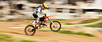 Motorcycle, balance and motion blur with a man on space at a race course for dirt biking. Bike, fitness and power with a person driving fast on sand or off road for freedom, performance or challenge