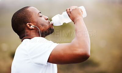 Buy stock photo Black man, runner and drinking water with earphones, music or podcast, relax and fitness outdoor. Hydration, health and plastic bottle, listening to radio on run with exercise, mockup space and train