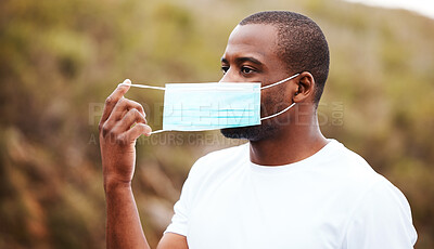 Buy stock photo Covid, outdoor and black man remove mask, safety and pandemic policy with freedom, breathing and decrease infection rates. African person, outside or guy take off face cover, regulations or protected