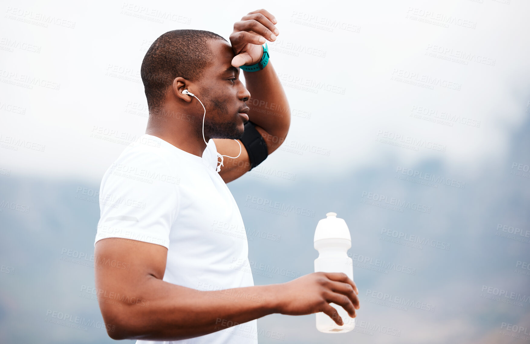 Buy stock photo Black man, runner and tired with water and earphones, music or podcast, relax and fitness outdoor. Hydration, health and plastic bottle, listen to radio on run with exercise, mockup space and train