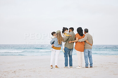 Buy stock photo Parents, grandparents and children at beach outdoor for hug, support and love in nature. Back of men and women or big family with kids on holiday, adventure or vacation at sea for banner space in sky