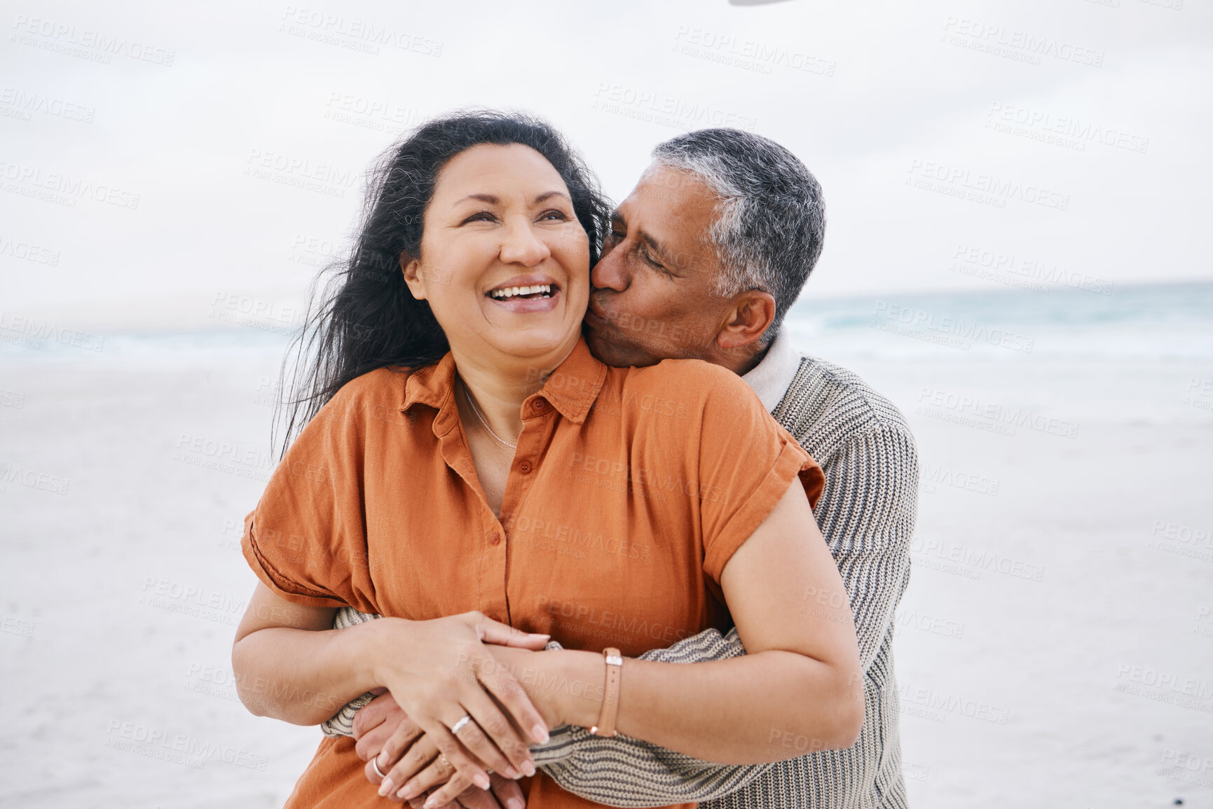 Buy stock photo Beach, hug and senior happy couple kiss, support and care on travel holiday, retirement vacation and affection in nature. Embrace, freedom and romantic elderly man, old woman or marriage people bond