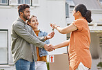 Keys, realtor handshake and couple moving to new house, property investment and mortgage success, deal or thank you. Young people shaking hands and giving lock to dream home and real estate agreement
