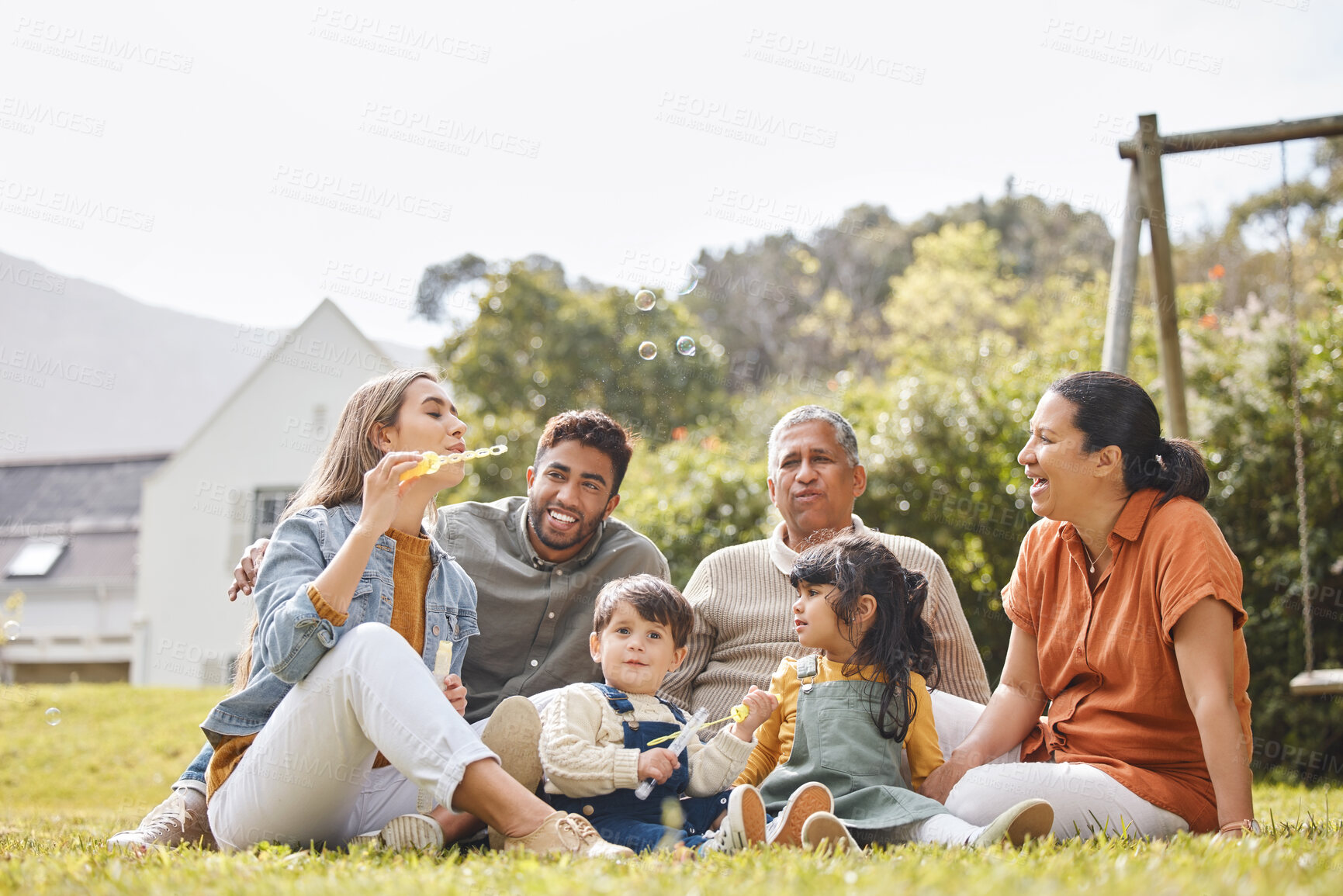 Buy stock photo Big family, grandparents and children for picnic, relax and bubbles on grass or garden outdoor in summer. Love, people and kids in backyard of home for care, freedom and bonding in nature or park