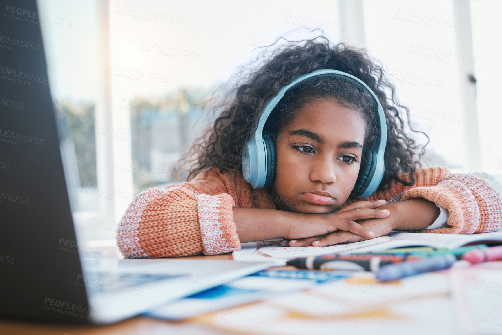 Buy stock photo Child, bored and thinking with headphones for home school, e learning and future online education. Tired, sad and girl kid with ADHD, autism and laptop for drawing and listening to audio at table