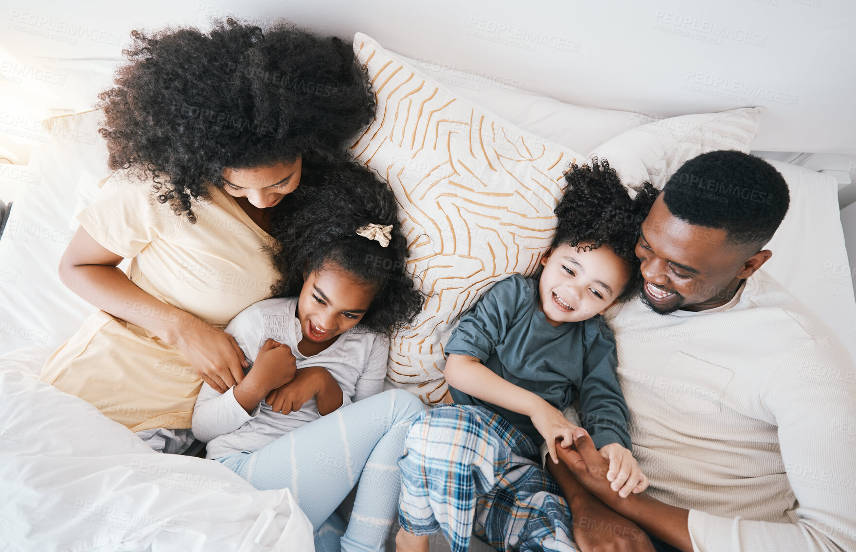 Buy stock photo Mom, father and kids in bed with tickling, comic joke and laugh in top view, care and love in family house. Black man, mother and daughter with smile, play game and crazy in bedroom, morning and home