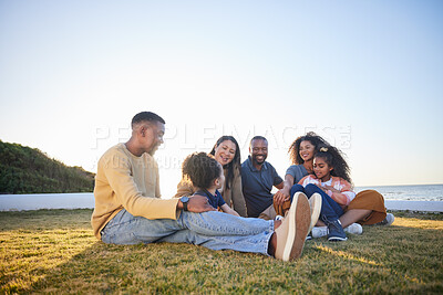 Buy stock photo Beach, happy and family relax on vacation, bonding and having fun together on grass on mockup space. Grandparents, smile and interracial parents with kids at ocean to travel on holiday, care and love