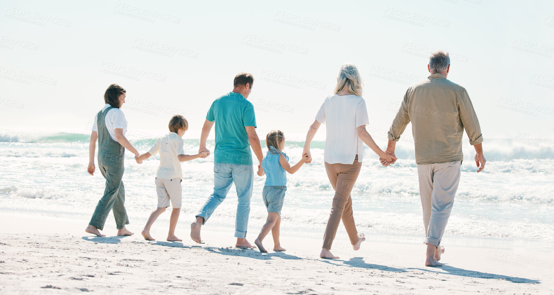 Buy stock photo Love, travel and holding hands with big family on the beach for support, summer vacation or bonding. Freedom, health and relax with people walking on seaside holiday for adventure, trust or happiness