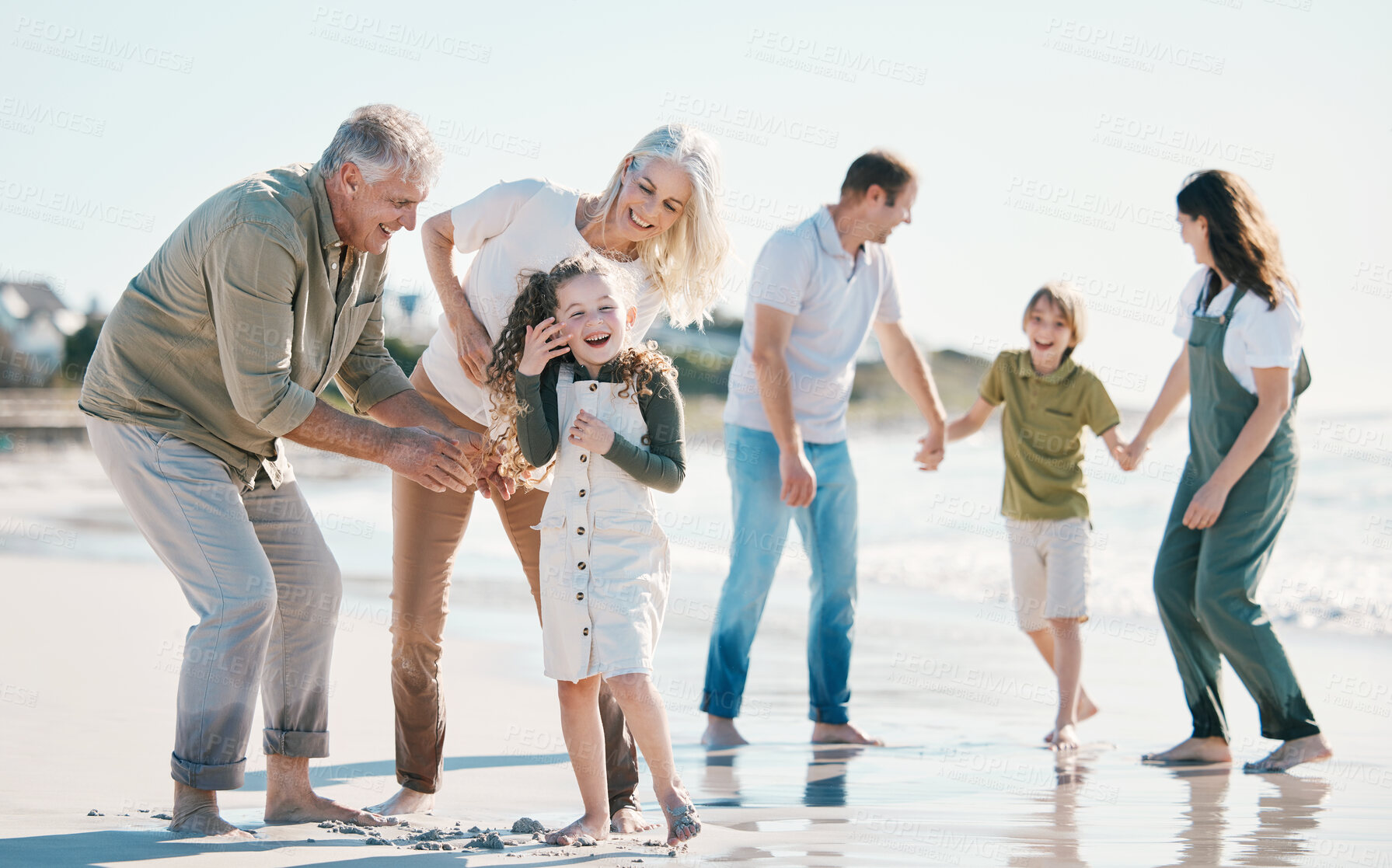 Buy stock photo Grandparents, kids and big family with play at beach, comic laugh or bonding for love, sunshine or excited on vacation. Men, women and children by sea, waves or happy for holiday for summer in Spain