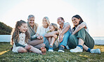 Parents, grandparents and children on grass by ocean for bonding, relationship and relax together. Nature, family and happy grandmother, grandfather and kids on holiday, vacation and travel by sea