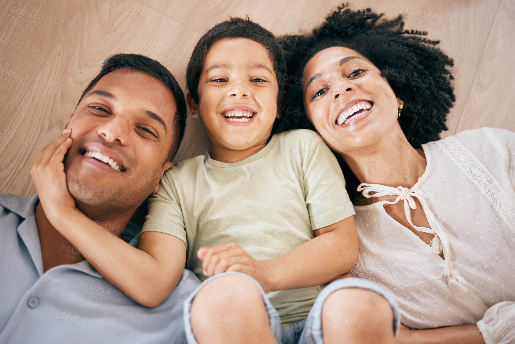 Buy stock photo Portrait, top view and family on the ground, smile and relax with love, bonding or playing together. Face, parents or mother with father, boy or child on the floor, happiness or kid with joy and home