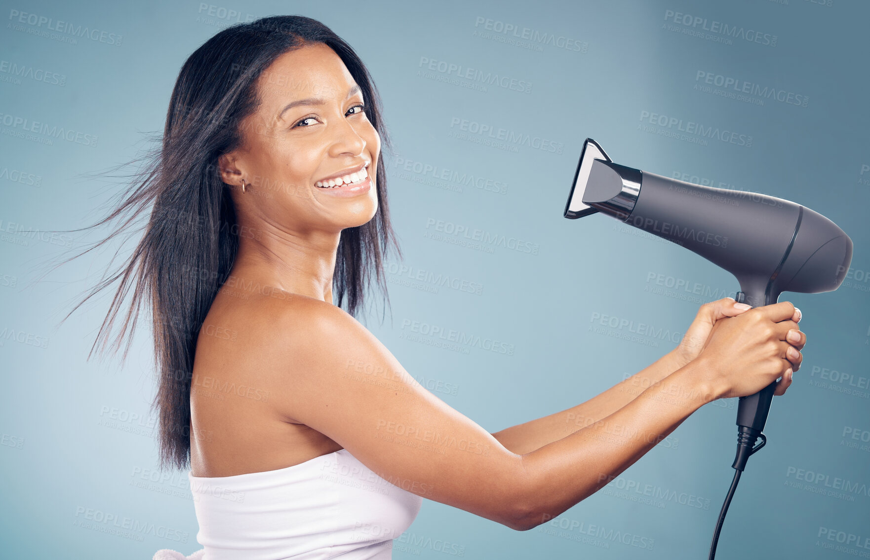 Buy stock photo Portrait, happy woman and blow dryer for hair care in studio isolated on a blue background. Face, natural beauty and hairdryer of model in healthy salon treatment, hairstyle wellness and hairdresser