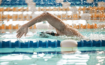 Exercise, sports and a swimmer in a pool during a race, competition or cardio training at a gym. Fitness, water and workout with an athlete swimming to improve speed, health or freestyle performance